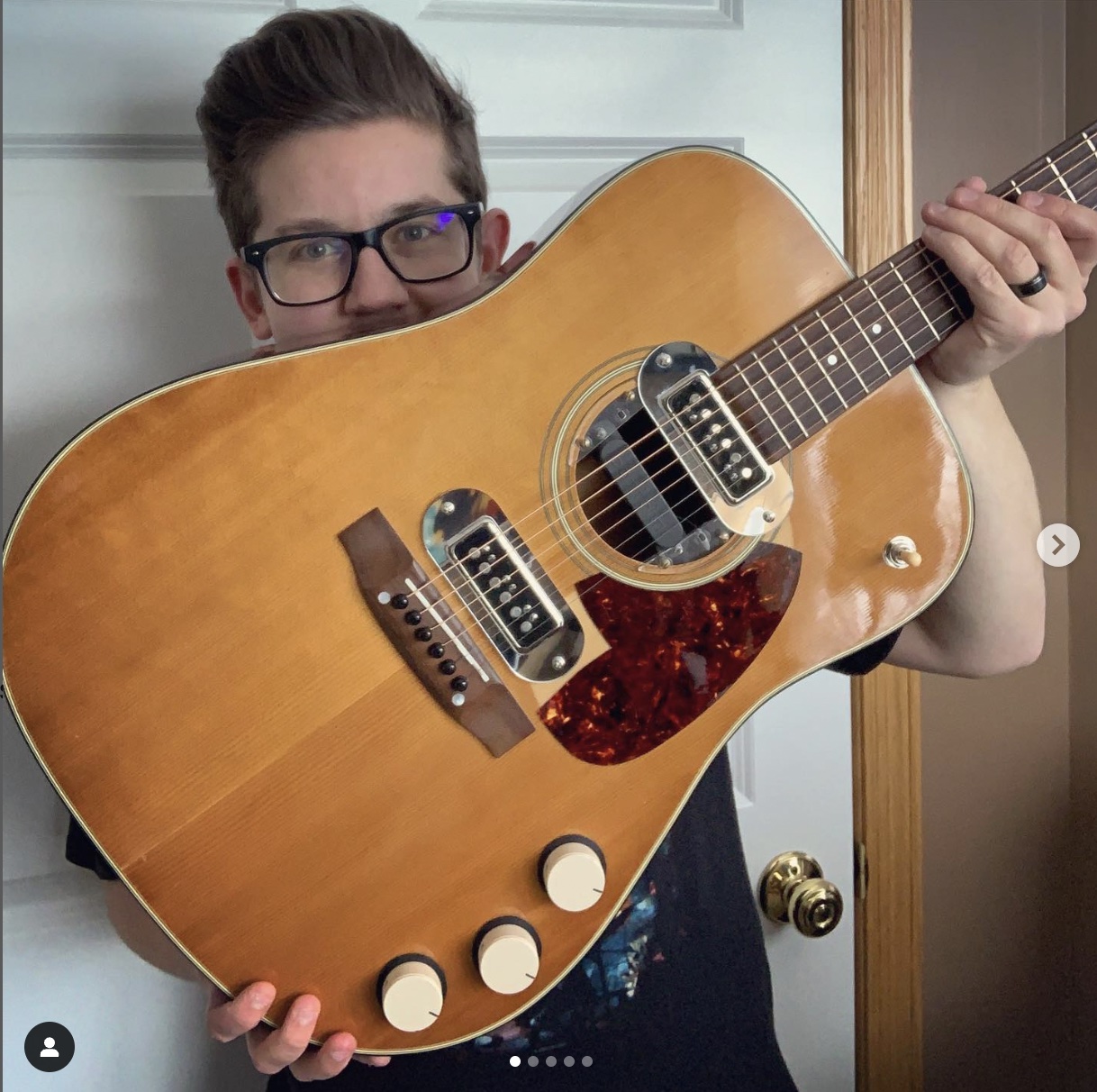 Eric of @nirvanaguitars holding up his remake of Kurt Cobain's guitar from the MTV Unplugged performance.